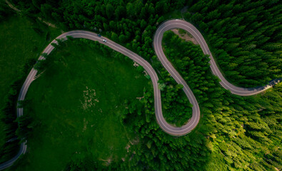 Aerial view of the road passing through the mountain and green forest. Curve asphalt road on mountain forest summer.	
