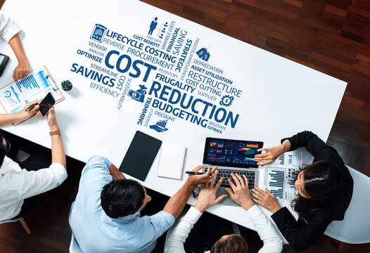 A dynamic business meeting focused on cost reduction strategies, featuring diverse professionals analyzing data and collaborating on innovative solutions for improved efficiency. Amity
