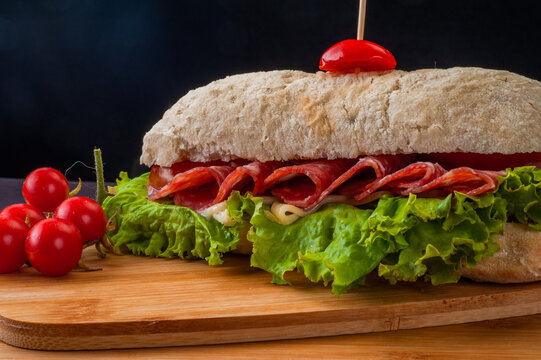 Sanduiche de presunto cru com tomate seco, salada verde e molho no p&atilde;o de croissant 