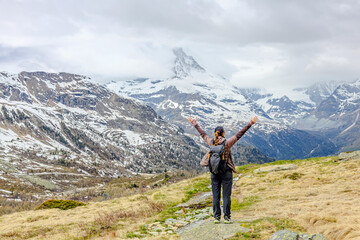 Hiker enjoying the breathtaking view of snow-capped mountains in Zermatt, Switzerland