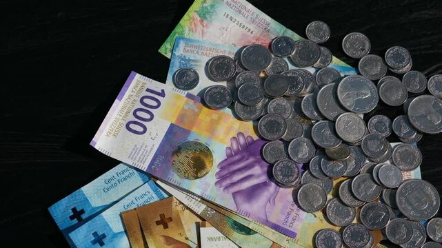 Schweizer Geld, Banknoten Geldscheine und M&uuml;nzen in der W&auml;hrung Schweizer Franken, Geldreserven Ersparnisse als drehender Hintergrund, Bargeld in der Schweiz