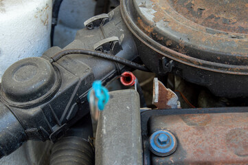 An engine part exhibits wear and rust, revealing exposed wiring and connectors, typical for an...