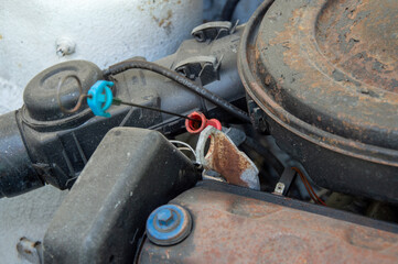 Mechanical assembly of an old car engine showcases worn parts and wiring, highlighting signs of age...