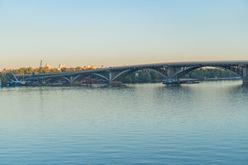 A stunning panoramic view of a city skyline, with a bridge over a serene river, capturing the blend...