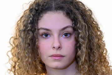 Un portrait en gros plan d'une jeune femme aux cheveux bouclés et à l'expression neutre
