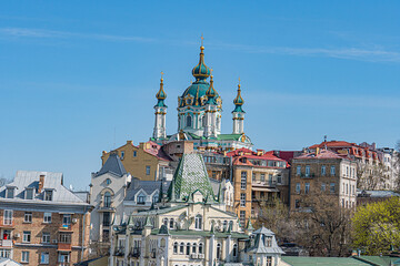 Old town with a Byzantine-influenced cathedral, multiple domes and towers, adorned with gold ornaments Surrounding structures exhibit classical architectural styles Warm earth tones contrast vibran