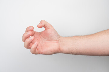 Close-up of a fair-skinned hand with curled fingers and extended thumb, against an indistinct...
