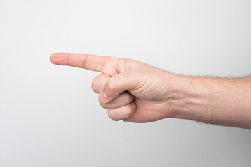Close-up of a light-skinned hand in an accusing gesture, against a neutral background.