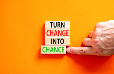 Turn change into chance symbol. Concept words phrase Turn change into chance on beautiful wooden blocks. Beautiful orange paper background. Business Turn change into chance concept. Copy space.