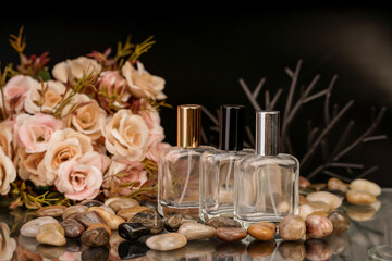 A pair of elegant fragrance bottles set against a black backdrop and rose bouquet.