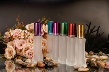 Sophisticated product photography featuring perfume bottles, flowers, and smooth stones.

