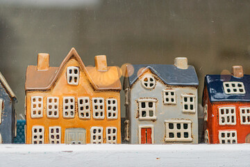 Miniature houses in varying colors and styles, each with multiple windows and doors Houses are...