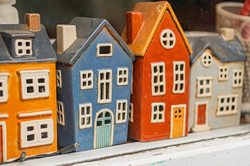 Miniature European-style houses in vibrant colors, arranged in a row, viewed from above Realistic...