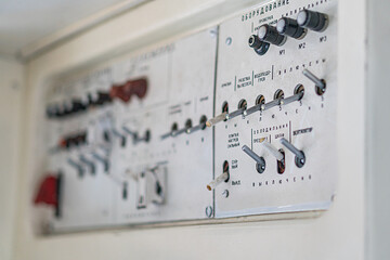 Industrial airplane control panel in an isolated setting, featuring metallic switches and dials