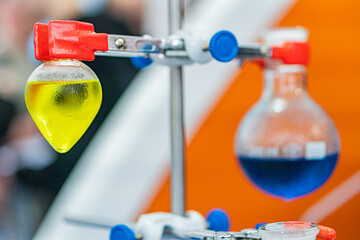 Laboratory setting with spectrophotometer, test tubes, vials, colored liquids clear, yellow, green,...