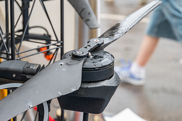 Close-up of electric combat quadcopter drone in motion, partially obscured human figure, wet...