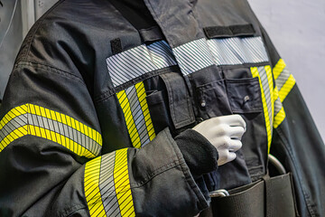 Close-up image of a functional firefighters uniform with high-visibility stripes, pockets, and...