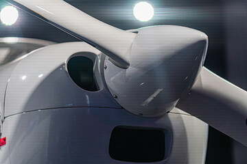 Close-up of a moving white propeller plane against an indistinct background, no windows or markings...