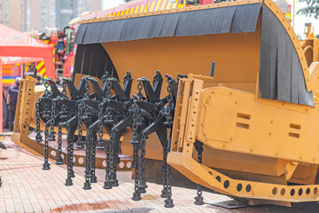 Yellow construction vehicle on display, likely a mine-clearing machine Articulated front...