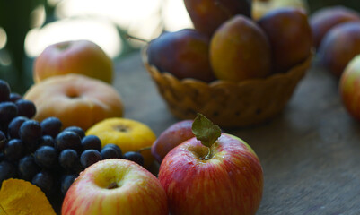 Black grapes, yellow leaves, various fruits on a blackboard