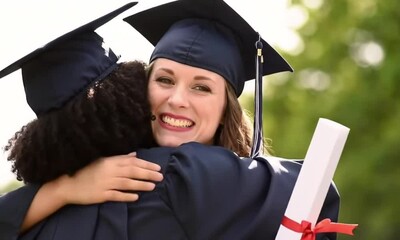 Two joyful graduates embracing during a graduation ceremony