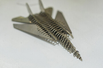 Miniature metallic jet fighter model with swept wings, detailed structure, uniform color scheme,...
