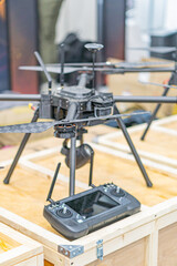 Two Ukrainian fpv drones on a wooden pallet, one large for professionalindustrial use and the other small for consumerrecreational Blurred industrial background suggests storage area or warehouse