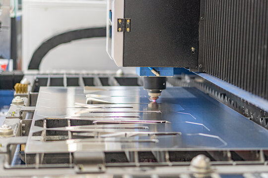 Close-up of operating robotic arm over conveyor belt in industrial setting, lined with metallic rectangular panels Dominant dark machinery, shadows, muted color palette black, grey, metallic No t