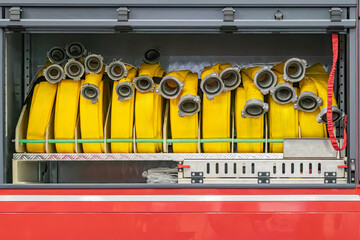 Yellow fire hoses in a green-padded, metal-barred compartment Indoor setting with artificial light