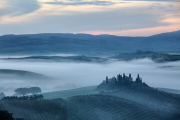 Naklejka premium The Belvedere farmhouse in Val d’Orcia with early morning fog, San Quirico d'Orcia, Tuscany, Italy