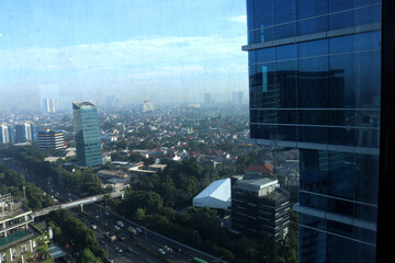 Urban landscape photo full of tall buildings, clouds and motor vehicles in a photo from above