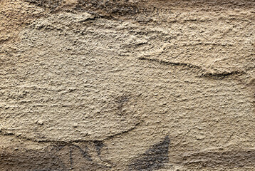 Golden textured wall with rough, grungy surface and antique pattern. Aged, weathered metal or stone