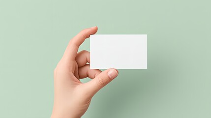 Hand holding a white business card.