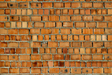 Old red brick wall with weathered texture. Detailed view of an aged red brick wall with visible...