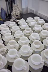 Neatly stacked white coffee cups for elegant events or catering, making a stylish presentation