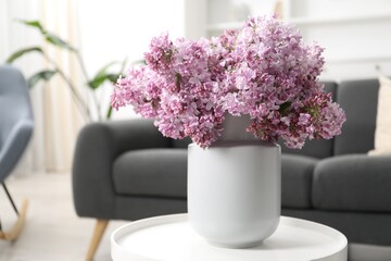 Beautiful lilac flowers in vase on table indoors, space for text