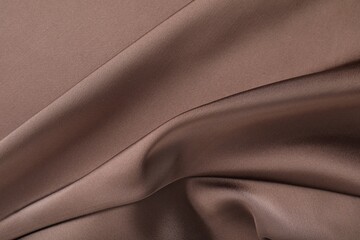 Crumpled light brown silk fabric as background, top view