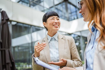 two multicultural female business woman collaborating new project