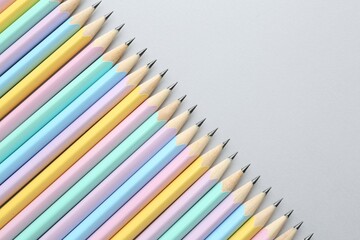 Many graphite pencils on light grey background, flat lay. Space for text
