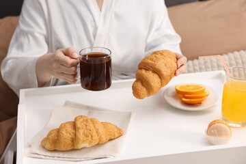 Woman having delicious breakfast in bed, closeup