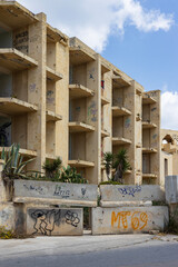 Marsaskala, Malta - 05.12.2025: An abandoned and forgotten empty shell of a hotel resort covered in...