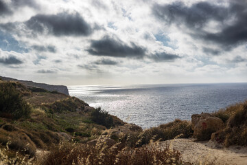 A dramatic cloudy sky over Mediterranean sea and the rugged coast of Malta. © Roksana Tomasiak