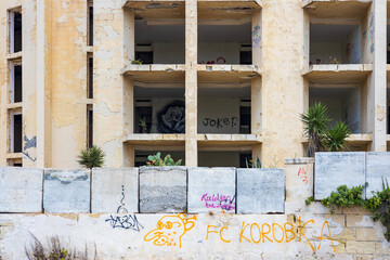 Marsaskala, Malta - 05.12.2025: An abandoned and forgotten empty shell of a hotel resort covered in graffiti located on the coast of Malta in Marsaskala region.