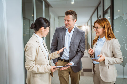 multicultural colleagues have informal meeting at company hallway - Powered by Adobe