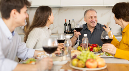 Happy family having dinner together at the festive table at home