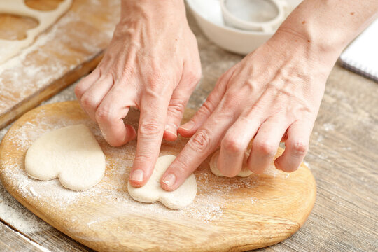 Making Heart Shaped Cookies for Loves Day. Close-up of male hands. Baking concept.