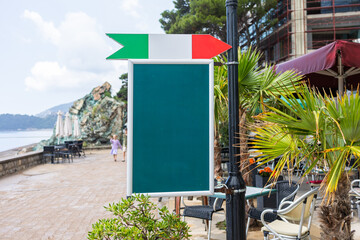 Wooden frame chalkboard stands on summer pavement. The concept shows outdoor signage, seasonal business, and blank advertising opportunity. Copy space.