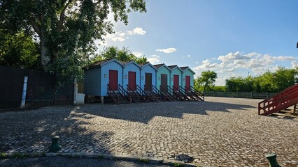 Colorful Wooden Cabins with Red Doors in Row – Rustic Outdoors Scene