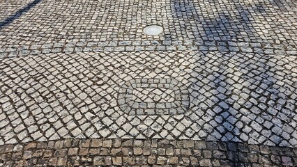 Portuguese pavement with circular mosaic detail and granite pattern