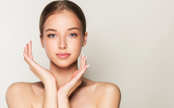 Fototapeta Beautiful young woman with clean fresh skin on face . Girl facial  treatment   . Cosmetology , beauty  and spa .